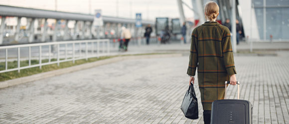 Travel Medicine - Appletree Occupational Health - Woman walking to aiport with suitcase